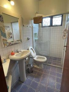 uma casa de banho com um lavatório e um WC em Casa Rosa Hospedaria em Araxá