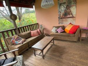 Casa Rosa Hospedaria في أراكسا: غرفة معيشة مع كنبتين وطاولة