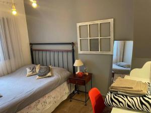 1 dormitorio con 1 cama y 1 mesa con silla en Casa Rosa Hospedaria en Araxá