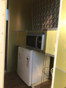 フロリアノポリスにあるTrailer Refúgio Shaktiの電子レンジ、冷蔵庫付きのキッチンが備わります。