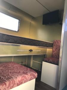 フロリアノポリスにあるTrailer Refúgio Shaktiのベッドと椅子が備わる小さな客室です。