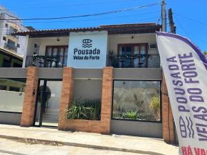 a sign on the front of a building with a banner at Pousada Velas do Forte in Cabo Frio