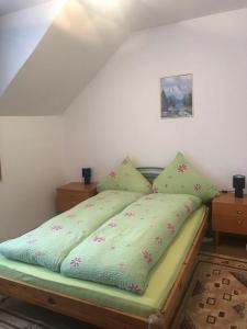a bed with a green comforter in a bedroom at Casa Stana in Cavnic