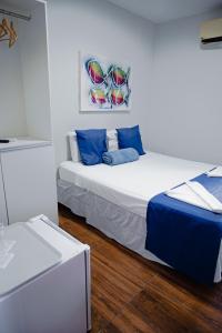 um quarto com 2 camas e almofadas azuis em Pousada Tropical Bessa em João Pessoa