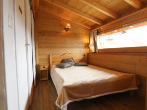 ラルプ・デュエズにあるAppartement Huez, 4 pièces, 6 personnes - FR-1-405-133の木造キャビン内のベッド1台が備わるベッドルーム1室を利用します。