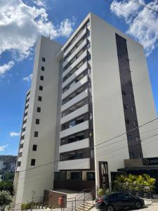 un gran edificio blanco con un coche aparcado delante en hihome - Metropolitan, en Juiz de Fora