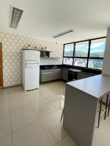 a kitchen with a white refrigerator and some windows at hihome - Metropolitan in Juiz de Fora