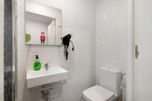 een badkamer met een zwarte kat op een plank boven een wastafel bij Apartamento Familiar in Moncarapacho