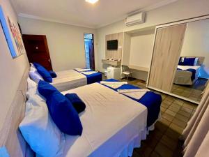 Habitación de hotel con 2 camas y almohadas azules en Pousada Tropical Bessa, en João Pessoa
