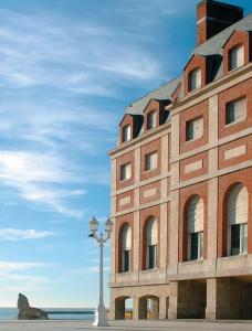 un gran edificio de ladrillo con una luz de la calle delante de él en Casa mia en Mar del Plata