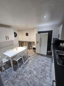 a kitchen with a white table and a refrigerator at Melior Grandiose in Liverpool