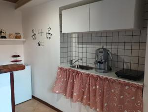 eine Küche mit einer Spüle und einer Kaffeemaschine auf der Theke in der Unterkunft Threehouses in Trecase