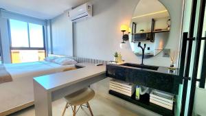 a bedroom with a desk and a bed and a mirror at Mare Intermares by Hosppedar in Ilha da Restinga