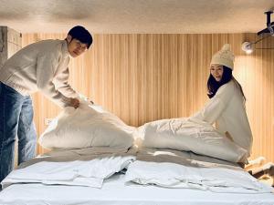 un homme et une femme debout au-dessus d'un lit dans l'établissement Sasa Youth Hostel, à Jiaoxi
