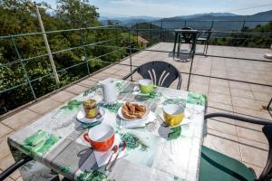 stół z talerzem jedzenia na balkonie w obiekcie 207 - Appartamento Mimosa, Terrazza, giardino e Piscina - Residence Cherry House w mieście Carro