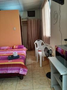 1 dormitorio con 1 cama, mesa y sillas en Mini suite en Garzota…., en Guayaquil