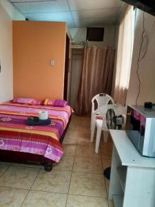 1 dormitorio con cama, mesa y barra en Mini suite en Garzota…., en Guayaquil