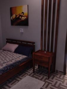 1 dormitorio con 1 cama, 1 mesa y 1 pintura en Chambre à proximité de l'aéroport., en Cotonou