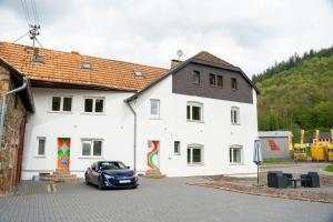 un'auto parcheggiata di fronte a un edificio bianco di The Ring Inn ad Adenau