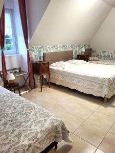 a bedroom with two beds and a table and a window at Petit Châtelet bis in Hirel +92 photos