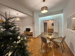 a living room with a christmas tree and a table and chairs at SKG City Center Apartment in Thessaloniki