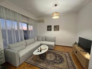 a living room with a couch and a tv at SKG City Center Apartment in Thessaloniki