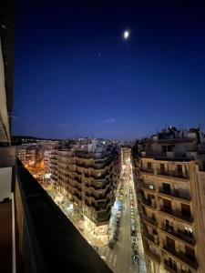a view of a city at night with the moon at SKG City Center Apartment in Thessaloniki