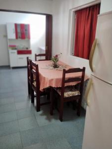 une table à manger avec un tissu de table rose et un réfrigérateur dans l'établissement Casa Interna Paraná, à Paraná