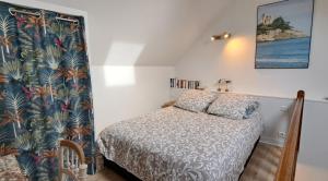 a small bedroom with a bed and a curtain at Clos de la Fontaine in Dinard