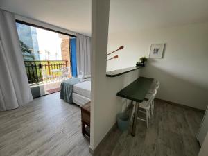 Zimmer mit einem Schreibtisch, einem Bett und einem Fenster in der Unterkunft Villaggio Orizzonte in Salvador