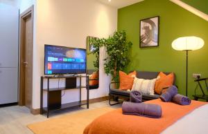 a living room with a couch and a flat screen tv at GoldersGreen Apartments by Sleepy in London