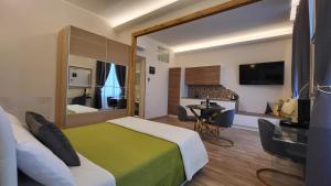 um quarto de hotel com uma cama, uma secretária e uma televisão em I Due Grifoni Studio Flat em Taormina