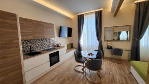 uma cozinha e sala de estar com mesa e cadeiras em I Due Grifoni Studio Flat em Taormina