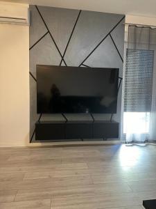 a living room with a large flat screen tv on a wall at Apartment Black and white in Zagreb