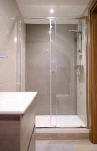 y baño con ducha y puerta de cristal. en GoldersGreen Apartments by Sleepy, en Londres