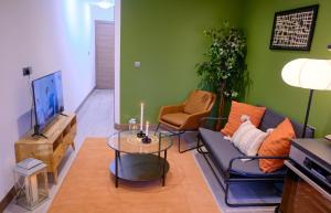 a living room with a couch and a tv at GoldersGreen Apartments by Sleepy in London