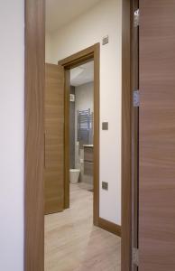 un couloir avec une porte menant à une salle de bains. dans l'établissement GoldersGreen Apartments by Sleepy, à Londres