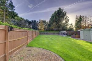 a backyard with a fence and a green yard at Wychwood House 