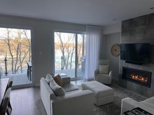 a living room with a couch and a fireplace at Le Riverain - Condo neuf au bord de l'eau in Shawinigan