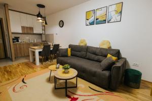 a living room with a couch and a table at Apartment Vista In Prestige in Zlatibor +12 photos
