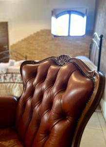 una sedia in pelle marrone in una camera con letto di Villa Alberto a Sulmona