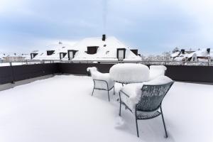 uma mesa e cadeiras cobertas de neve numa varanda em Tonirooms Penthouse em Straubing