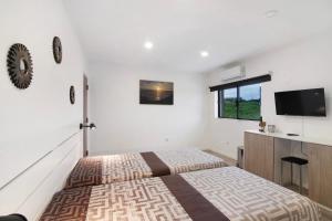 1 Schlafzimmer mit 2 Betten und einem Flachbild-TV in der Unterkunft Apartamento Mar in Moncarapacho