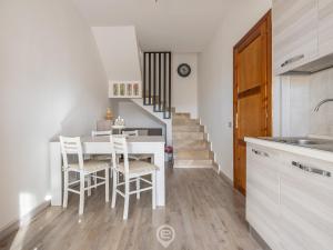 Una cocina y un comedor con mesa y sillas. en Maria's Wonderful Retreat, en Villasimius
