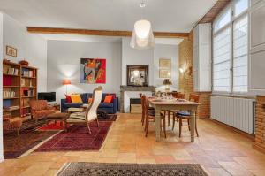 een woonkamer met een blauwe bank en een tafel bij L'encrier - Appt confortable pour 2 in Toulouse