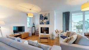 ein Wohnzimmer mit 2 weißen Sofas und einem TV in der Unterkunft strandnahe FeWos mit Terrasse oder Dachterrasse, Strandhaus Seeblick, Binz in Binz