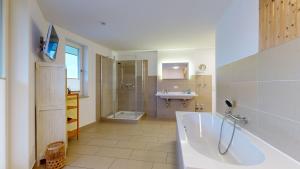 ein großes Badezimmer mit Badewanne und Waschbecken in der Unterkunft strandnahe FeWos mit Terrasse oder Dachterrasse, Strandhaus Seeblick, Binz in Binz + 37 Fotos