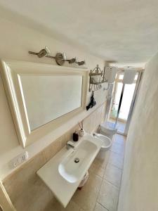 a bathroom with a white sink and a toilet at A Casa di Caterina in Polignano a Mare