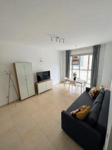 uma sala de estar com um sofá preto e uma mesa em Apartamento 1ª línea Patacona em Valência