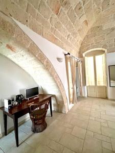 an attic room with a desk and a stone wall at A Casa di Caterina in Polignano a Mare